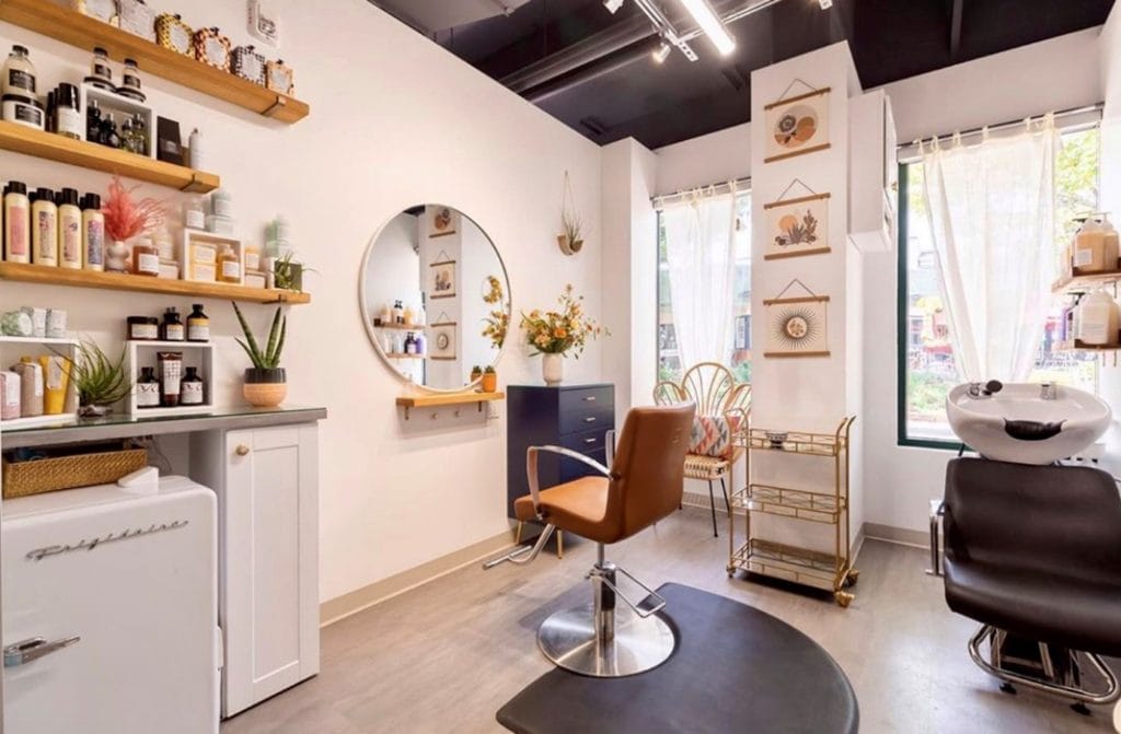 Coin soin du salon, étagères de produits et miroir rond